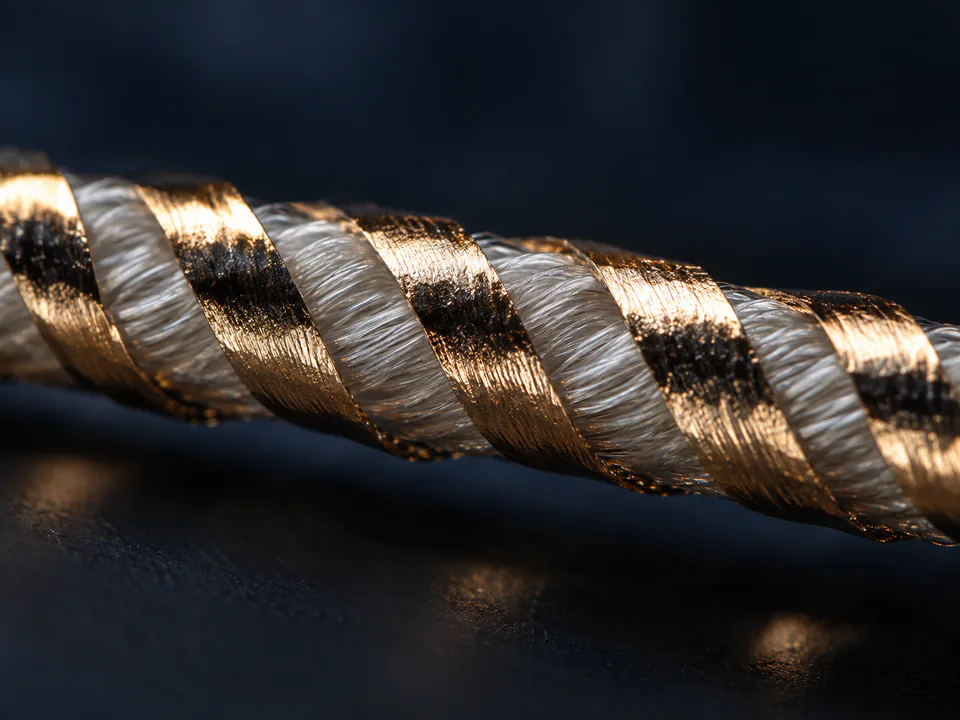 Gold metallic film helically covering a white textile filament core for ST Type yarn